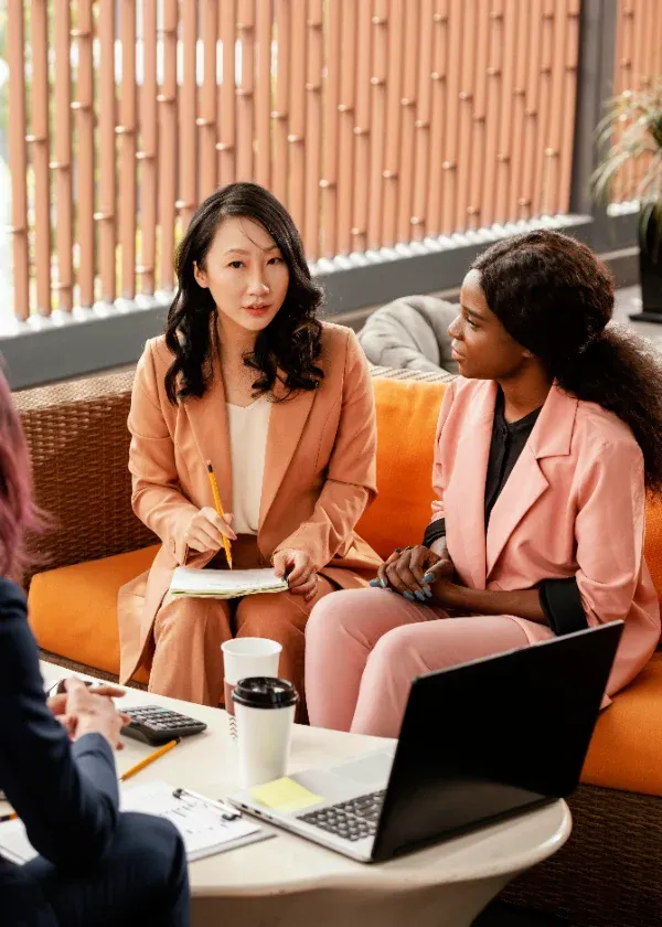 Four women in discussion around a meeting table